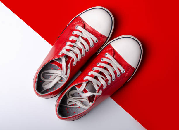 istock Red sneakers on red white background 1089816530