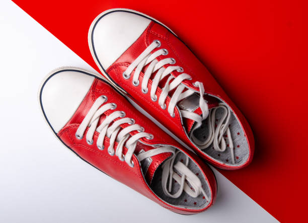 istock Red sneakers on red white background 1089816534