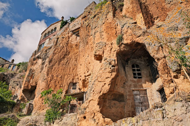 Civita di Bagnoregio, Viterbo, Lazio, Italy: the rock face of the tuff hill with caves and rock-cut cellars Civita di Bagnoregio, Viterbo, Lazio, Italy: the rock face of the tuff hill where it was built the medieval village with caves and rock-cut cellars tufa photos stock pictures, royalty-free photos & images