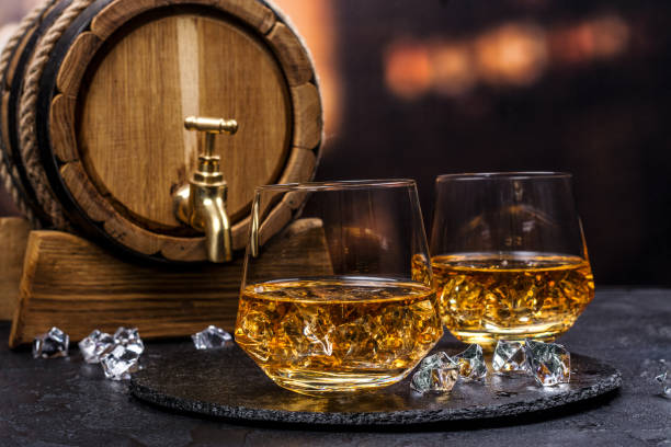 Two glasses of Cognac with ice cubes stock photo