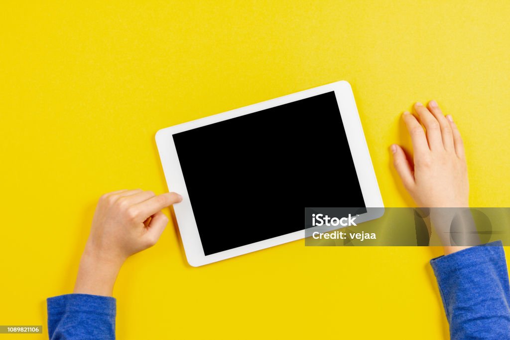 Kind-Hände mit Tablet-PC auf gelbem Hintergrund - Lizenzfrei Tablet PC Stock-Foto