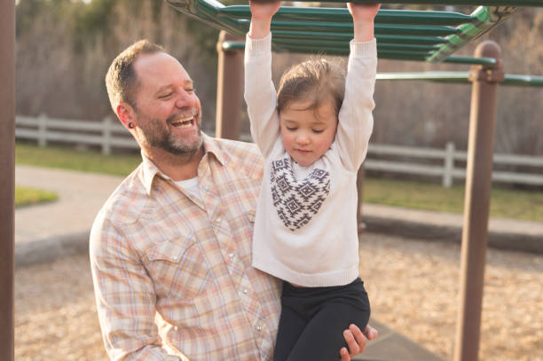 istock Dad teaches his daughter how to swing on the monkey bars 1089823568