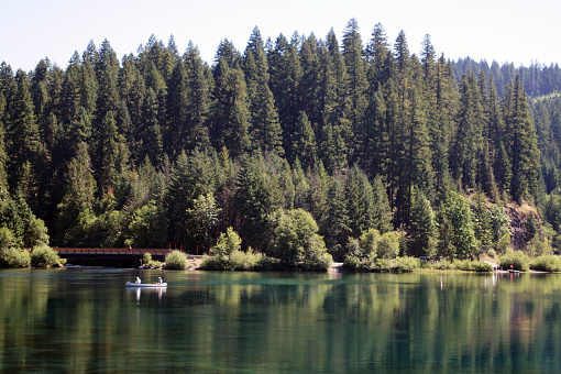 Lake in the middle of an American forest with two fishermen in a boat