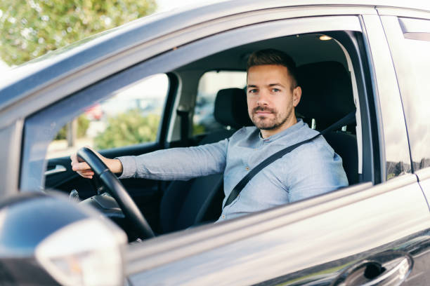 istock Responsible caucasian handsome bearded guy driving car and looking at camera. Hand on steering wheel. 1089840468