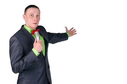 Amazed presenter or businessman with microphone in the hands is showing on a copy space isolated on a white background. Breaking news.