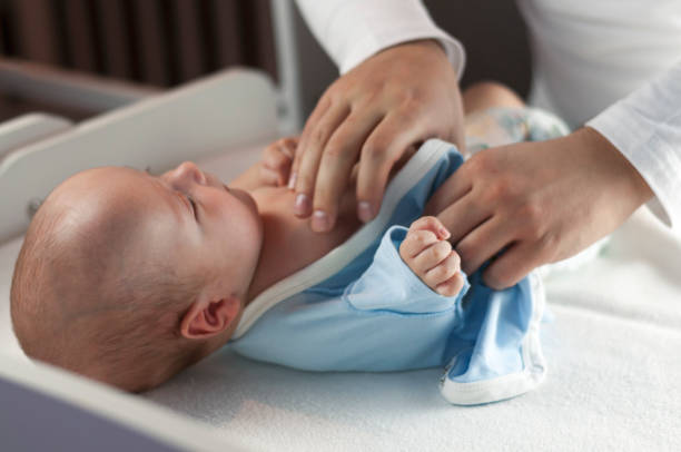 istock Young dad changes the diaper and clothes to his newborn small child. Selective focus. 1089851982