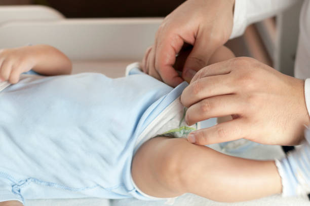 istock Young dad changes the diaper and clothes to his newborn small child. Selective focus. 1089851994