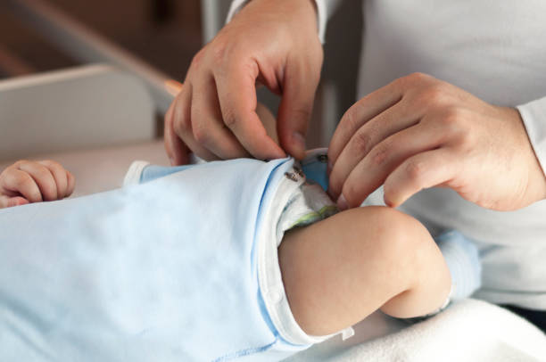 istock Young dad changes the diaper and clothes to his newborn small child. Selective focus. 1089852012