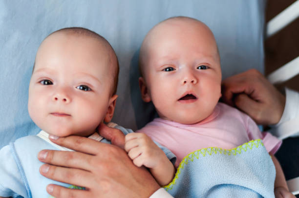 istock Young father with his newborn twins lying in bed. Selective focus 1089852154
