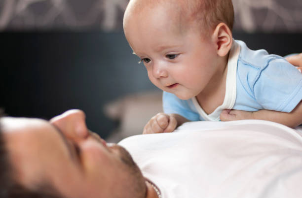 istock Young father with his newborn twins lying in bed. Selective focus. 1089852260