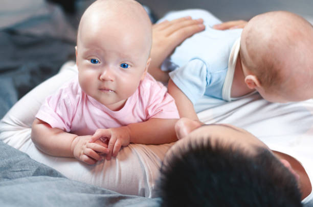 istock Young father with his newborn twins lying in bed. Selective focus. 1089852380