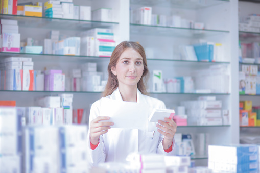 Pharmacist reading prescription preparing medicine