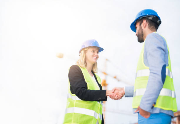 istock Two mid adult engineers shaking hands on a construction site. 1089869068