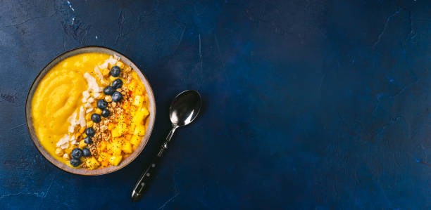 istock Top view of mango smoothie bowl with fruits 1089871342