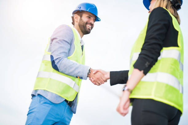 istock Two mid adult engineers shaking hands on a construction site. 1089875738
