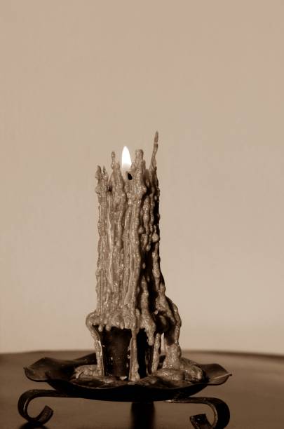 istock Lit sepia toned burning candle in old holder 1089880756