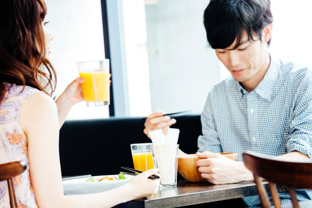 istock Young Asian couple having lunch in restaurant 1089886792
