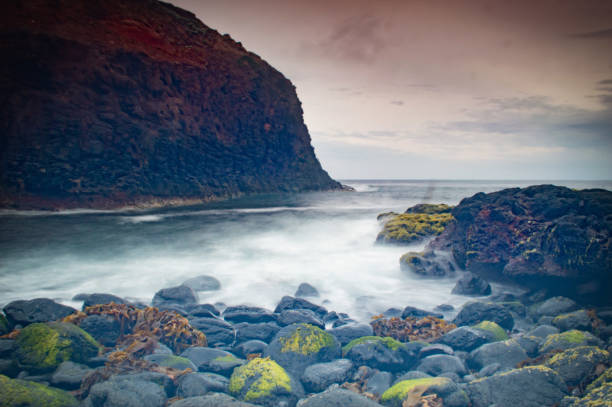 istock Sunset of beach with rocks 1089931378