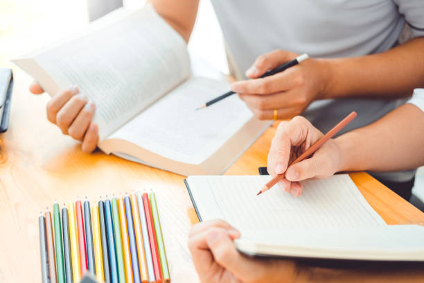 istock High school or college students studying and reading together in library 1089938538