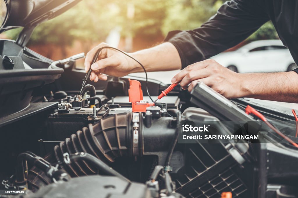 Auto mecánico trabajando en garage técnico de manos de coche mecánico trabajando en auto reparación servicio y mantenimiento coche batería comprobar. - Foto de stock de Coche libre de derechos