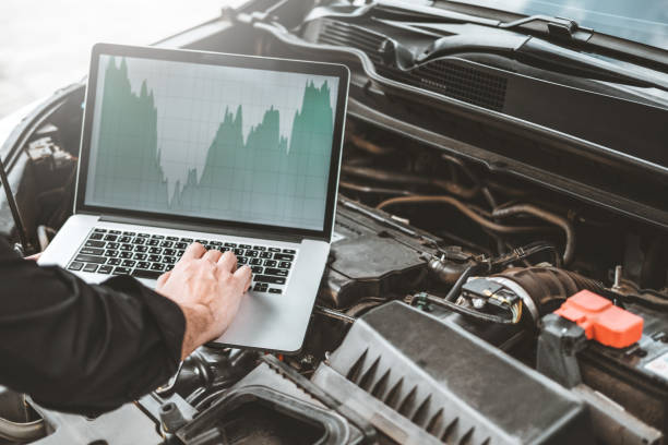 professionelle fachmann hands zur überprüfung der reparatur von motormotoren mit laptop auf dem auto - car battery car battery auto repair shop stock-fotos und bilder