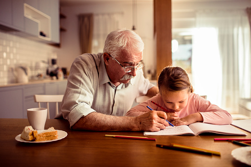 Close up of a grandfather helping his granddaughter with schoolwork