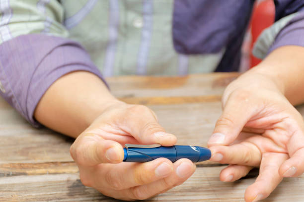 istock Man taking blood sample with lancet pen indoors. Diabetes concept. 1089971420