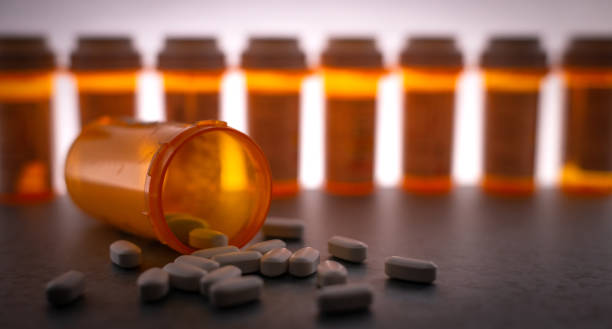 Prescription Medication Prescription medication is strewn about, with pill bottles in the deep background. fentanyl stock pictures, royalty-free photos & images