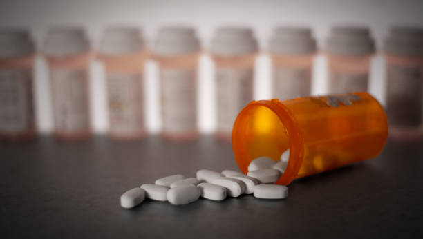 Prescription Medication Prescription medication is strewn about, with pill bottles in the deep background. fentanyl addiction stock pictures, royalty-free photos & images