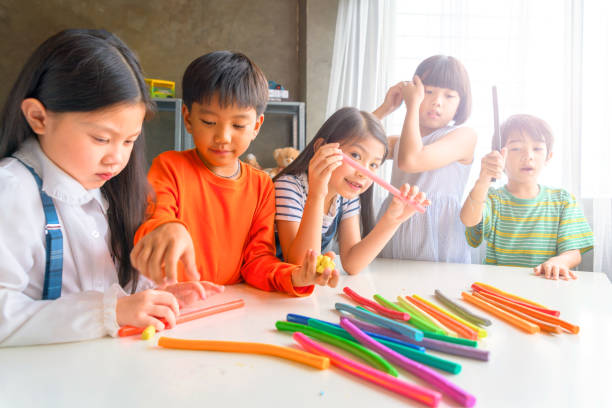 crianças asiáticas brincando com argila colorida do jogo em casa ou jardim de infância ou playschool - sleeping high school desk education - fotografias e filmes do acervo