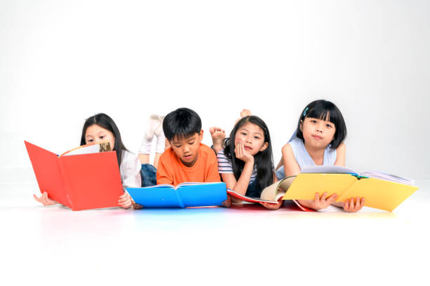 un grupo de lindo poco asiatico y niña lectura libro mientras sentada o acostada sobre fondo blanco - sleeping high school desk education fotografías e imágenes de stock