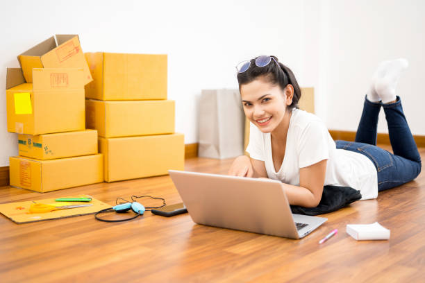 istock Young Asian small business owner working at home office, taking note on purchase orders. Online marketing packaging delivery, startup SME entrepreneur or freelance woman concept 1089981758