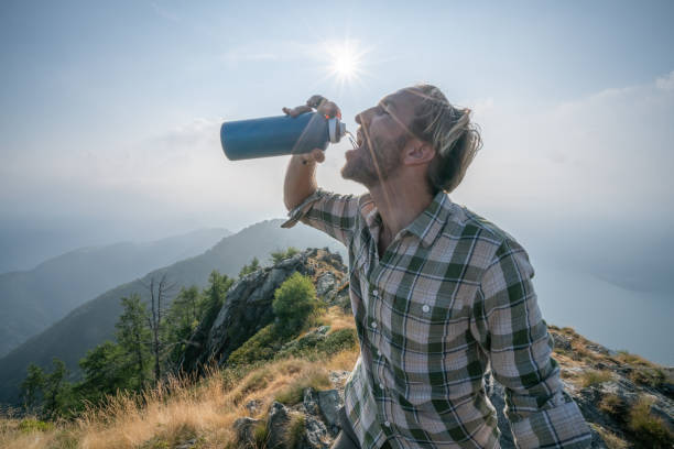istock Hiker male drinking on mountain trail from water bottle 1089987274