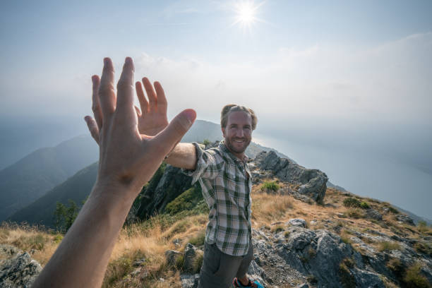 istock Personal perspective of Two hikers celebrating on mountain top with a high five 1089987384