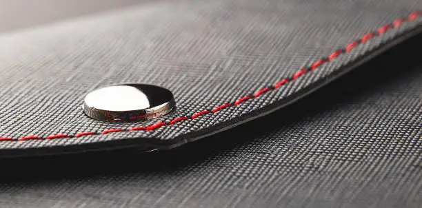 Leather black close up, rivet and red thread business style background