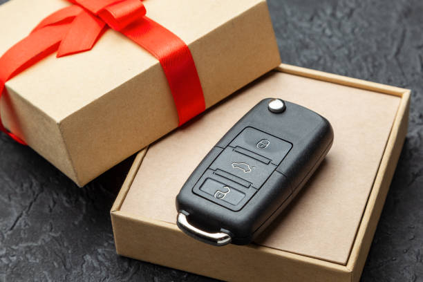 istock Gift box with car keys with remote control alarm system with red ribbon bow. 1089997176