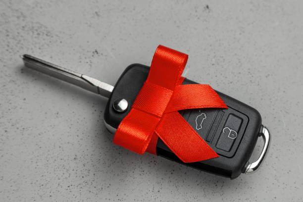 istock Gift Car keys with remote control alarm with red ribbon with bow. Gray background. 1089997272
