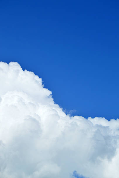 istock A vertical click of white bright clouds in open bright blue sky. 1089997410