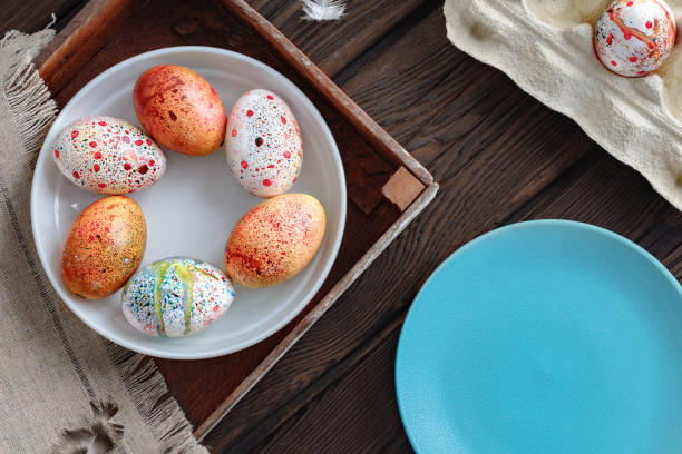 istock painted colored Easter eggs on a plate in a wooden box on a dark wooden background 1090000428