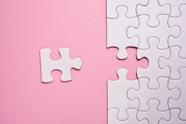 istock Incomplete white jigsaw puzzle pieces on pink background 1090008106