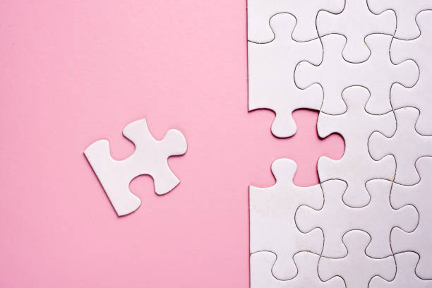 istock Incomplete white jigsaw puzzle pieces on pink background 1090008108