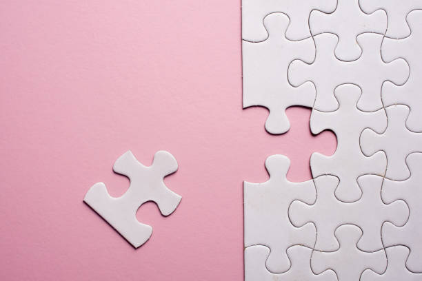 istock Incomplete white jigsaw puzzle pieces on pink background 1090008180