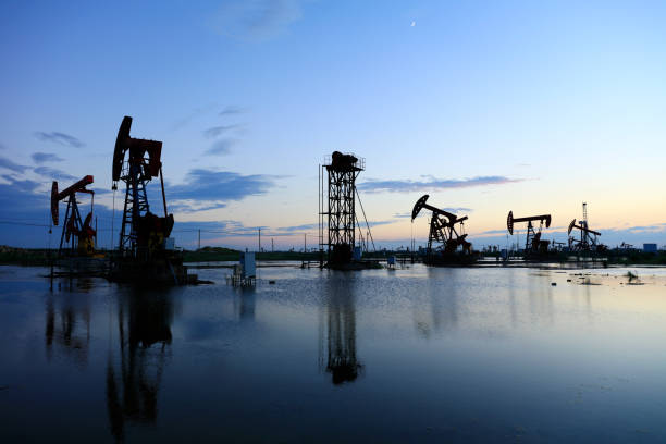 campi petroliferi la sera, campo petrolifero derrick la sera, tramonto e tramonto - oil production foto e immagini stock