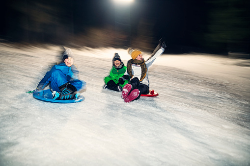 Three kids having extreme winter fun on sleds. Panning and flash 
Nikon D850