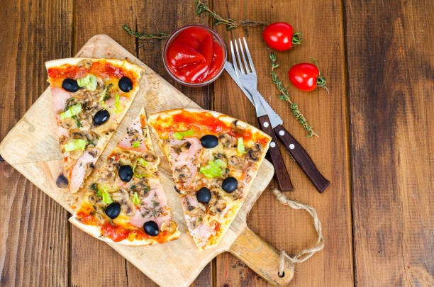 istock Sliced pizza with mozzarella cheese, ham, mushrooms, olives 1090016312