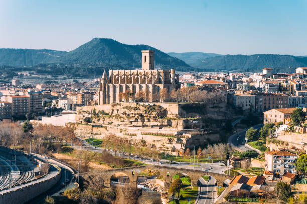 different and original view of Collegiate Basilica of Santa Maria Seu in Manresa city in catalunya region in Spain, with landscape of all the city stock photo