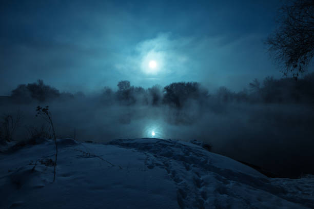 natten mystiska landskap. fullmåne över dimmig älv. snötäckta åstranden. - moon forest bildbanksfoton och bilder