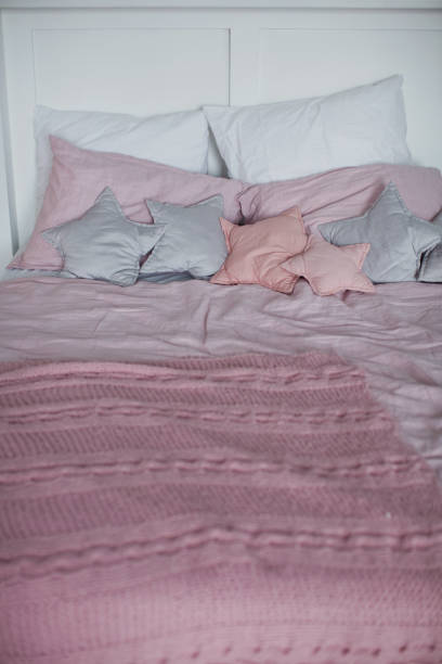 istock bed with pink and gray bedding and star shaped pillows 1090024832