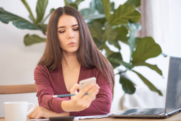 istock woman is distracted while working on her phone. social networks at work, effective employees in a modern office. 1090026190