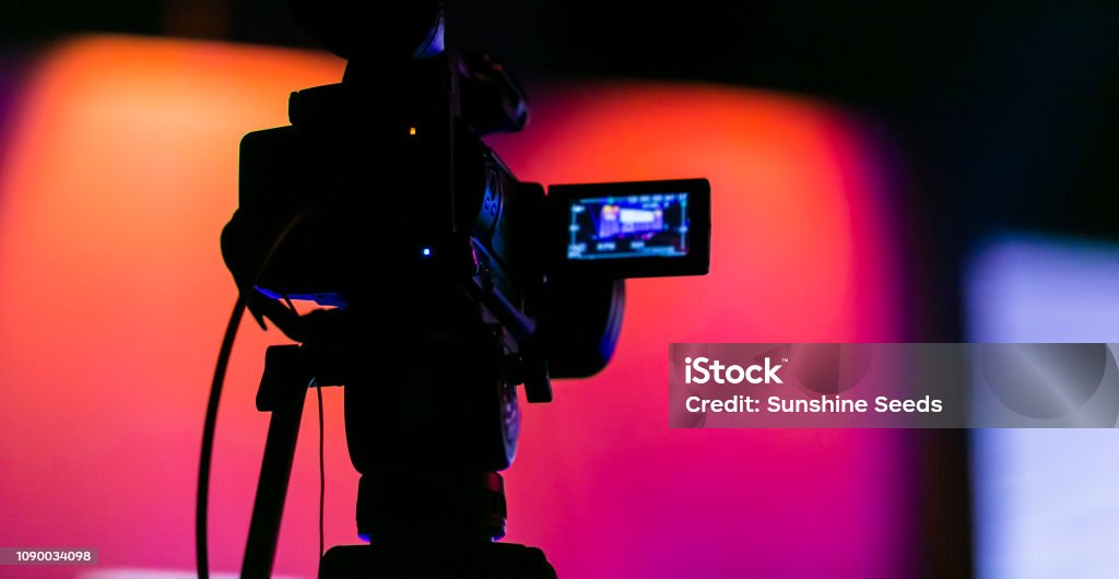 Silhouette of a TV Camera filming a live broadcast Live Streaming Stock Photo